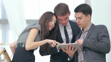 Aralarında bir kadın ve iki erkeğin de yer aldığı neşeli bir grup genç, bir tableti incelerken etkileyici iş sonuçlarını hevesle tartışıyor. Animasyon ifadeleri ve işbirlikçi ruhları heyecan ve başarı atmosferi yaratır.
