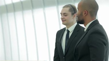 Parlak, modern bir ofiste, dört kendine güvenen iş adamı canlı bir tartışmaya girişiyor, gülümsemeleri başarı ve dostluk saçıyor. Atmosfer, fikirleri paylaştıkça, takım çalışmalarını ve hırslarını gösterdikçe enerjiyle doludur.