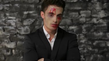 Pürüzsüz siyah takım elbiseli bir erkek vampir, sert tuğla bir arka plana karşı öfkeli bir ifadeyle saate bakıyor. Bu çarpıcı Cadılar Bayramı temalı görüntü gotik korkunun özünü yakalıyor, zarafeti aciliyetle harmanlıyor.