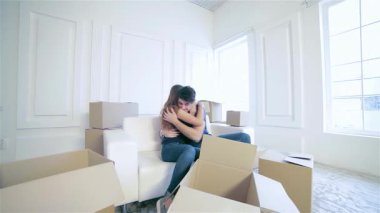 Neşeli bir çift sıcak beyaz bir kanepeye oturur, sıcak bir kucaklaşmaya sarınırlar, parlak, boş dairelerinde paketlenmemiş kutularla çevrili. Sahne aşk ve heyecan saçıyor, yolculuklarına başlarken yeni başlangıçların özünü yakalıyor.