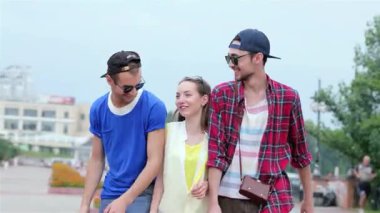 Üç genç arkadaş açık havada kaygısız günlerinin tadını çıkarırken gülüşlerini ve kahkahalarını paylaşıyorlar. Canlı kıyafetleri ve neşeli ifadeleri arkadaşlığın özünü ve yaz maceralarının neşesini yansıtıyor.