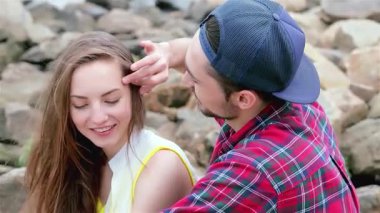 Neşeli bir çift, deniz kenarında neşeli bir anın tadını çıkarır. Güneş onların gülümsemelerine sıcak bir parıltı saçar. Kaygısız gülüşleri ve sevgi dolu jestleri hatıraları yakalamak için mükemmel bir sevgi ve dostluk atmosferi yaratıyor.