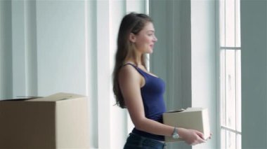 Sevgi dolu bir çift yeni evlerine taşınmanın heyecanıyla eğleniyor. Etrafı kutularla çevrili. Elinde bir karton kutu tutan genç kadın, partneri neşe içinde gözlerini kapatırken, mutluluk ve şaşkınlık dolu bir an yaratıyor.