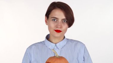 Kırmızı dudaklı neşeli bir kadın, şakacı bir şekilde yüzünü güzel oyulmuş bir balkabağı fenerinin arkasına saklar, neşeli bir ruh yayar. Bu hoş sahne, Cadılar Bayramı 'nın özünü yakalıyor. Gelenek ve eğlenceyi canlı bir sonbahar atmosferinde harmanlıyor.