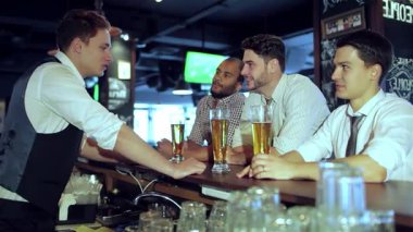 Dört genç iş adamının kahkahalarını ve bira bardaklarını tokuşturup TV 'deki bir futbol maçının heyecanına daldıkları canlı bir sahne gözler önüne seriliyor. Tezahürat ve arkadaşlıkla dolu barın canlı atmosferi,