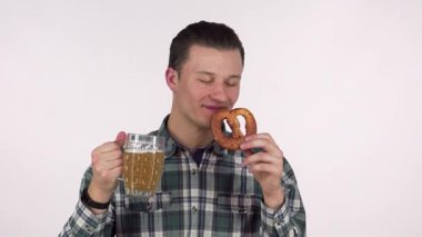 Neşeli genç bir adam bir elinde soğuk bir bardak bira diğer elinde sıcak, altın bir çubuk kraker tutarken heyecanla ışıldıyor. Ekose gömleği bu şenlikli sahneye moda katıyor. Kutlama ve hoşgörü ruhunu somutlaştırıyor.