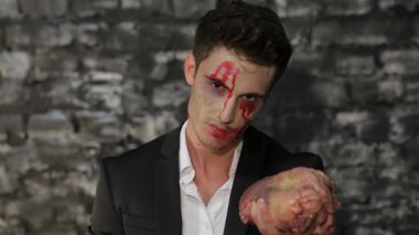 Gösterişli siyah bir takım elbise giymiş çarpıcı bir vampir figürü kanlı bir et parçasını sert tuğla bir duvara dayıyor. Ürpertici atmosfer vampirlerin yoğun bakışlarıyla güçlenir ve Cadılar Bayramı 'nın özünü somutlaştıran makyajla kaplanır.