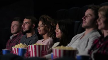 Neşeli bir grup arkadaş, sıcak bir sinemada kahkaha ve patlamış mısır paylaşan komik bir filme hayran kalıyor. Atmosfer, en sevdikleri atıştırmalıkların tadını çıkarırken heyecan dolu. Birlikte unutulmaz anılar yaratıyorlar.