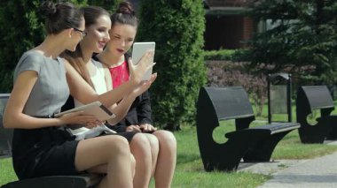 Üç genç, şık kadın ofis dışında, heyecan ve takım çalışmalarını sergileyen bir iş sözleşmesini zevkle tartışıyor. Canlı kıyafetleri ve çekici ifadeleri, hırsla dolu modern bir şirket atmosferini yansıtıyor.