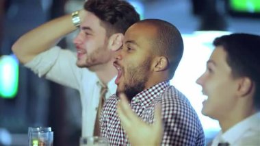 Canlı bir sahne dört arkadaş olarak gözler önüne seriliyor, şık gündelik giysiler içinde, heyecanlı bir barda heyecanlı bir futbol maçı izlerken tutkuyla tezahürat yapıyor ve bira bardaklarıyla kadeh kaldırıyorlar. Atmosfer heyecan dolu, kahkahalarla dolu.