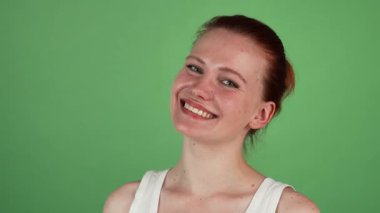 Canlı bir stüdyo portresi neşeli kızıl saçlı bir kadın yakalıyor, kendine güveni tam yeşil renkli arka planda bir 