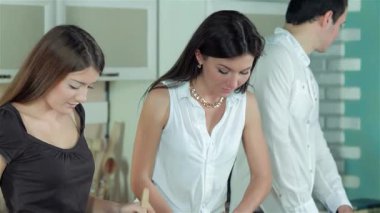 Üç neşeli arkadaş parlak bir mutfakta hareketli sebzeler doğruyor ve besleyici bir akşam yemeği için taze malzemeler hazırlıyorlar. Kahkahaları, rengarenk bir salata yaratırken havayı dolduruyor. Yemek pişirmenin ve arkadaşlığın neşesini somutlaştırıyor.