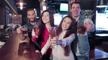 Dört arkadaş, iki erkek ve iki kadının coşkulu bir şekilde toplanıp neşeli bir barda kutlama yapmaları. Kadehlerini kaldırarak arkadaşlığın ve heyecanın simgesi olarak en sevdikleri futbola tezahürat ve içkinin keyfini çıkarıyorlar.