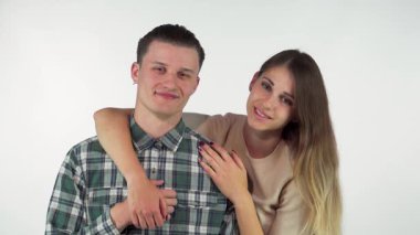 Sevimli genç bir çift samimi bir kucaklaşmayı paylaşıyor, birbirlerine sıcakkanlılıkla ve sevgiyle bakıyorlar. Çekici kadın, yakışıklı erkek arkadaşının kollarını nazikçe sarıyor. Sevgi ve bağlarla dolu sıcak bir ortam yaratıyor.