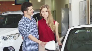 Çekici genç bir çift, galeride üstü açık şık bir arabayı inceliyor. Heyecan ve şefkat saçıyorlar. Kareli tişört giymiş yakışıklı adam elini nazikçe güzel kız arkadaşlarının omzuna koyar.