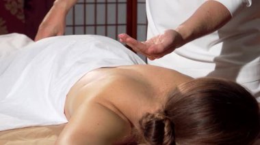 Yetenekli bir erkek masör rahatlamış bir bayan müşterinin arkasına nazikçe aromatik yağ sürerek masaj deneyimi için zemin hazırlar. Petrolün sıcak parıltısı cildin doğal güzelliğini arttırır. Huzurlu bir atmosfer yaratır. Tam ona göre.