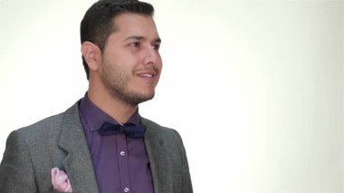 Şık takım elbiseli şık bir işadamı, olumlu ve başarılı bir şekilde başparmak kaldırırken kendine güvenen bir gülümseme sergiliyor. Temiz beyaz bir arkaplan ile belirlenmiş, ifadesi profesyonelliği ve güvenceyi somutlaştırıyor, onu şirket için mükemmel kılıyor.