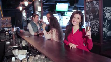 Neşeli bir kızın işten sonra kutlama yapan arkadaşlarıyla çevrili birasını tuttuğu hareketli bir barda canlı bir sahne başlıyor. Kahkahalar ve tezahüratlar havayı doldururken, arkadaşlar futbol takımını tutkuyla destekliyor.