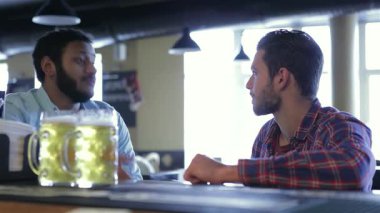 Canlı bir bar ortamında, iki mutlu genç adam buzlu biralarının tadını çıkarırken heyecanlı bir sohbete girişiyor. Atmosfer kahkaha ve yoldaşlıkla uğulduyor, dostluğu kutluyorlar ve birlikte neşeli anları paylaşıyorlar.