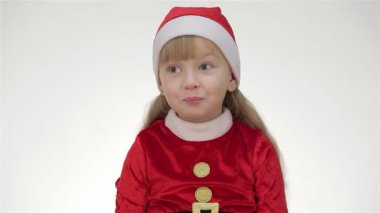 Noel Baba şapkalı çekici bir genç kız stüdyo ortamında neşeli bir şekilde poz verirken neşe saçıyor. İfade dolu yüzüyle, bir hediye sunuyor, saate bakıyor, susturucu bir jest yapıyor ve bir oyuncak ayıya sarılıyor, Noel ruhunu somutlaştırıyor.