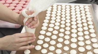 Odaklanmış bir pasta şefi ustalıkla borularını ustalıkla çırpar ve aşçılık sanatını gözler önüne serer. Pişirmenin tatlı aromasıyla dolu el değmemiş mutfak ortamı, onun enfes bir şey yaratmaya olan bağlılığını vurguluyor.