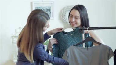 İki neşeli kız, moda tercihlerini keşfederken zevkle şık elbiseler seçiyor, kahkaha ve heyecan paylaşıyorlar. Enerjik enerjileri ve yoldaşlıkları canlı bir alışveriş ortamı yaratarak deneyimi unutulmaz kılıyor.