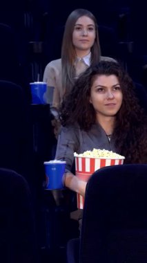 İki erkek ve dört kızın yer aldığı canlı bir grup genç arkadaş, rahat bir tiyatroda önlerinde sergilenen sinematik büyüye hayran kaldılar. Elinde büyük bir kova patlamış mısır ve renkli içeceklerle yüzleri neşe ve heyecanla parlıyordu.