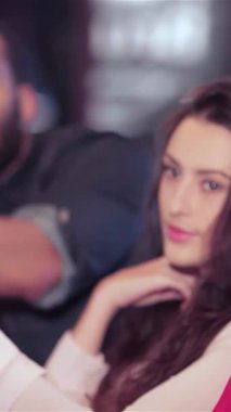 Neşeli bir grup genç arkadaş, hem erkek hem de kadın, neşe dolu bir barda bira bardaklarıyla coşkulu bir şekilde kadeh kaldırıyorlar, kahkaha ve heyecanla. Atmosfer, en sevdikleri futbol takımı için tezahürat yapmanın heyecanıyla uğulduyor.