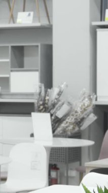 Şık sarı saçlı şık bir kadın modern bir mobilya mağazasında çağdaş dekorlarla dolup taşarken canlı havluları dikkatle inceliyor. Anlayışlı bakışları, düşünceli bir şekilde, iç tasarıma karşı bir tutku ortaya koyuyor.