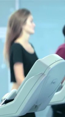 Bir grup tutkulu sporcu, hem erkek hem de kadın, modern koşu bantlarında koşuyor, enerji yayıyor ve fitness hedeflerine bağlılıklarını gösteriyorlar. Moda spor kıyafetleri, tonlu fizikleri ve odaklanmış ifadeleri heyecan verici bir şey yaratıyor.