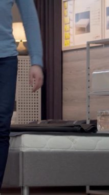 Neşeli bir çift şık bir mobilya mağazasında şık vitrinler ve yumuşak ışıklandırmalarla çevrili ideal ortopedik yatağı seçiyor. Canlı kızıl saçları ve ekose gömleği olan kadın, kocasıyla sevgi dolu bakışlarını paylaşıyor.