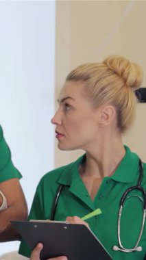 Parlak, modern bir hastanede, kendini adamış yeşil üniformalı sarışın bir hemşire kolları bağlı duran genç, sakallı bir doktordan hayati talimatlar alır. Bu dinamik sahne güzel bir şekilde özünü temsil eder.