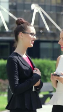 Hareketli bir şehir ortamında, kendine güvenen genç bir iş kadını parlak tabletinden haber okuyarak profesyonellik yayıyor. Yakınlarda, şık meslektaşları, enerjik bir işbirliği ve başarı ortamı yaratarak, canlı bir konuşma yapıyorlar.