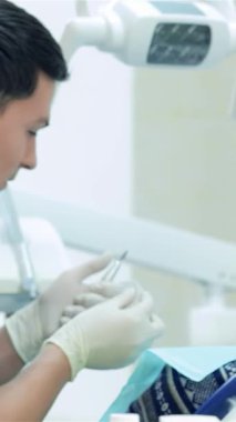 Kendini işine adamış mavi önlük ve eldivenlerle donanmış dişçi titizlikle dişçi aletleri hazırlar. Parlak ve modern bir klinikte hassasiyet ve bakım gösterir. Bu samimi sahne, hasta sağlığına olan bağlılığı ve profesyonelliği...