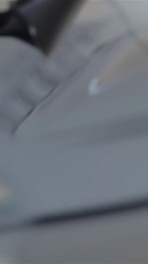 Yeni maceraların heyecanını somutlaştıran şık bir erkek eli, özel dikim bir takım elbise içinde şık bir araba kapı kolunu sıkıca kavrıyor. Bu büyüleyici an, modern bir galeride müşterileri davet eden lüks araçların cazibesini vurgular.