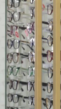 Şık sakallı, şık bir genç adam şık bir optometri dükkanındaki şık gözlükleri hevesle fotoğraflıyor. Parlak ışıkla aydınlatılan hareketli çerçeveler, bu modern dünya için heyecan verici bir atmosfer yaratıyor.