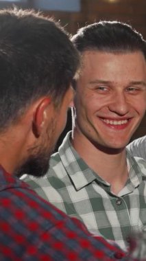 Yakışıklı erkek arkadaşlardan oluşan canlı bir toplantı, keyifli bir şekilde bira bardaklarını tokuşturur, kahkaha ve dostluk dolu bir barda eğlenirler. Sıcak ışıklandırma ve kırsal dekor ile vurgulanan davetkar atmosfer, iş sonrası için mükemmel bir zemin oluşturuyor.