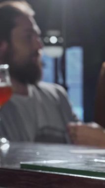 Cilalı tezgahın üzerinde çarpıcı bir bira bardağı parıldarken, neşeli bir grup arkadaş coşkulu barda kadehlerini sevinçle tokuşturuyor. Bar ışıklarının sıcak, davetkar parlaklığı herkesi rahatlamaya teşvik eden neşeli bir ortam yaratır.