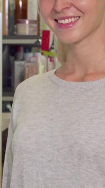 Parlak bir gülümsemesi olan neşeli bir kadın, kendinden emin bir şekilde eczanede memnuniyetini ifade eden canlı yeşil haplar sergiliyor. Renkli eczane arka planı bir sağlık ve refah hissi yayıyor ve tüketicileri kendi dünyalarını keşfetmeye davet ediyor.