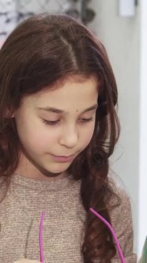 Enfes bir yakın plan çekimde güzel bir genç kadın ve sevimli kız kardeşi canlı gözlük mağazasında son moda güneş gözlüğü modelliği yaparken neşe saçıyorlar. Neşeli gülümsemeleri ve canlı çevreleri bir mutluluk ortamı yaratıyor.