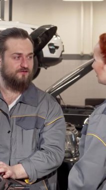 Canlı bir otomobil atölyesinde sakallı bir tamirci, profesyonel gri tulumlar giyen bayan meslektaşıyla araba tamiratlarını tartışır. Kaputu açık, somut takım çalışması olan bir aracın motorunu yakından incelerler.