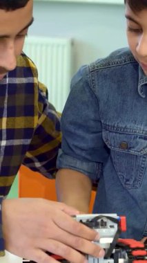 Çekici bir baba ve küçük esmer oğlu neşeli bir şekilde canlı bir oyuncak olan ATV 'yi bir festival masasında keşfetmekle meşguller. Genç Afrikalı Amerikalı, oyuncak konsolundaki renkli düğmelere hevesle basan oğluyla kahkahaları paylaşıyor.