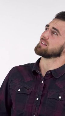 Yakışıklı, sakallı bir adam, etrafındaki ezici sesi engellemek için kulaklarını sımsıkı kapatarak sıkıntı içinde yüzünü buruşturuyor. Bu canlı görüntü anksiyete ve strese karşı mücadeleyi güçlü bir şekilde iletir. Teselli ararken hissettiğimiz saf duyguyu yakalar.