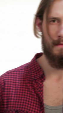 Çekici, bakımlı ve uzun saçlı genç bir hippi çağdaş bir stüdyoda el değmemiş beyaz bir arkaplana karşı güvenle poz veriyor. Ekose gömleği ve yoğun bakışları, bu görüntüyü ideal kılacak, modern bir hava yayıyor.