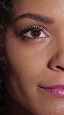 Neşeli genç bir kızın yakın plan portresi. Işıl ışıl gülüşü sinema sihrini deneyimlemenin sevincini yayıyor. Parlak gözleri ve kıvırcık bukleleri bir tiyatronun büyüleyici atmosferini yansıtıyor, kahkaha ve heyecanın iç içe geçtiği,