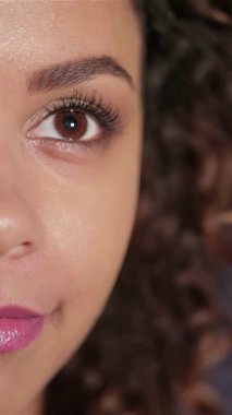 Neşeli genç bir kızın yakın plan portresi. Işıl ışıl gülüşü sinema sihrini deneyimlemenin sevincini yayıyor. Parlak kahverengi gözleri ve kıvırcık saçları bir tiyatronun büyüleyici atmosferini yansıtıyor.