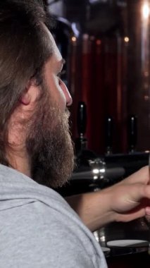 İki genç adam, buzlu bardaklarını altın zanaat birasıyla doldurarak keyifle tokuşturuyor, sıcak bir barın tadını çıkarıyorlar. Hayat dolu atmosfer kahkaha ve arkadaşlıkla dolu. Arkadaşlığın basit zevklerini ve paylaşılan anları kutluyorlar.