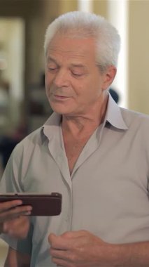 Canlı yeşil üniformalı şefkatli genç beyaz bir doktor gri saçlı bir ihtiyarla sıcacık bir dijital tablet üzerinde hayati sağlık bilgilerini göstererek yakınlaşıyor. Bağlantının bu samimi anı,