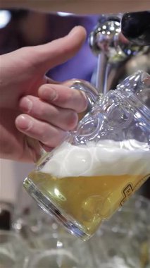 Becerikli bir barmen, gece hayatı ve yoldaşlığın enerjisini yakalayan soğuk bardağa ustalıkla altın bir bira döker. Işıldayan musluktan köpüren bira şelaleleri, mükemmel köpüklü bir kafa oluşturarak susamış müşterileri tadını çıkarmaya çağırıyor.