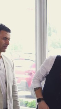 Üç şık adamın galeride yepyeni bir arabanın geniş bagajını hevesle incelediği canlı bir sahne gözler önüne seriliyor. Animasyon ifadeleri ve etkileyici sohbetleri, dostluk ve heyecan yayar, keşfin heyecanını yakalar.